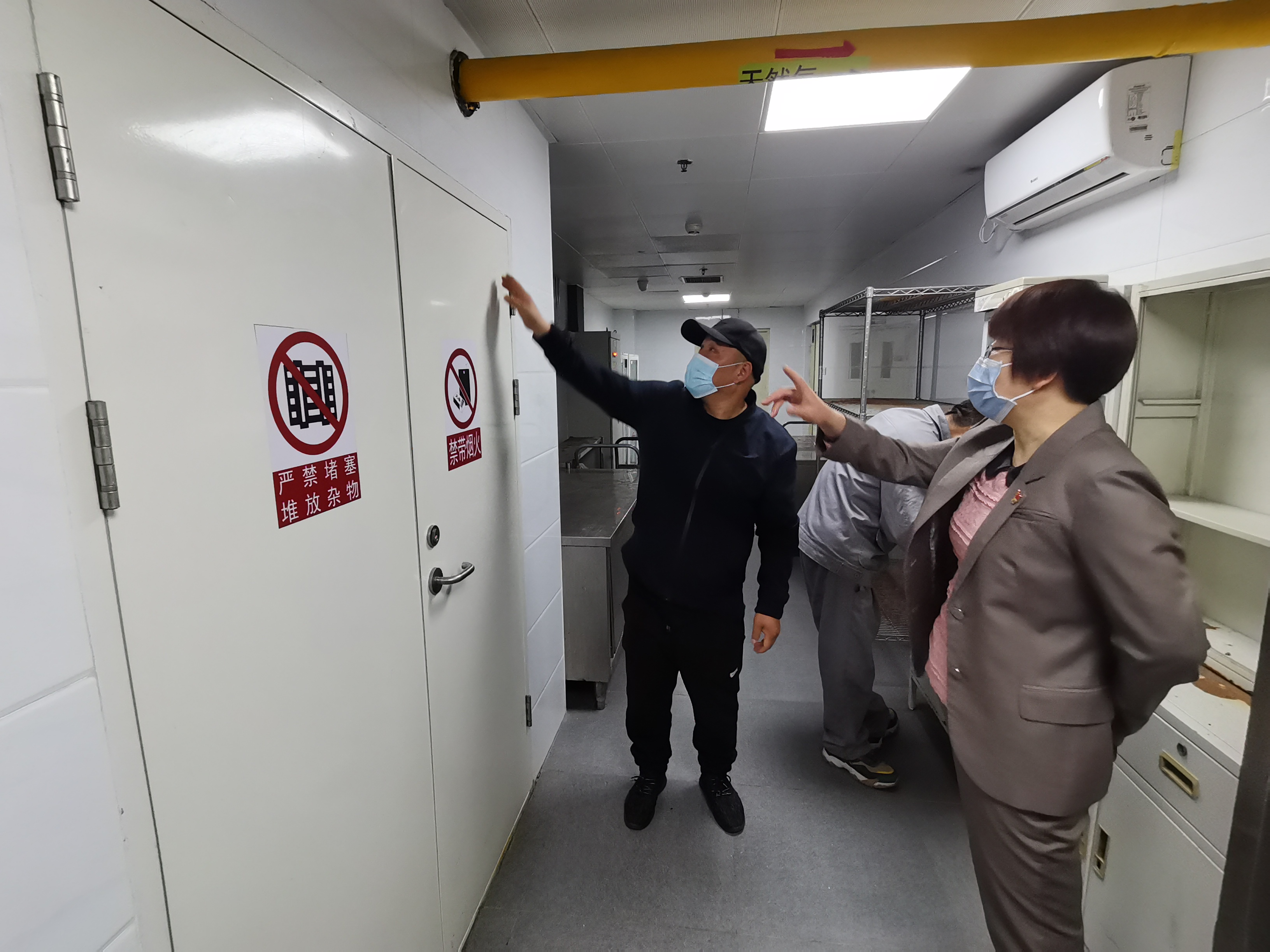 图为中心主任李雪梅正在检查食堂安全管理情况