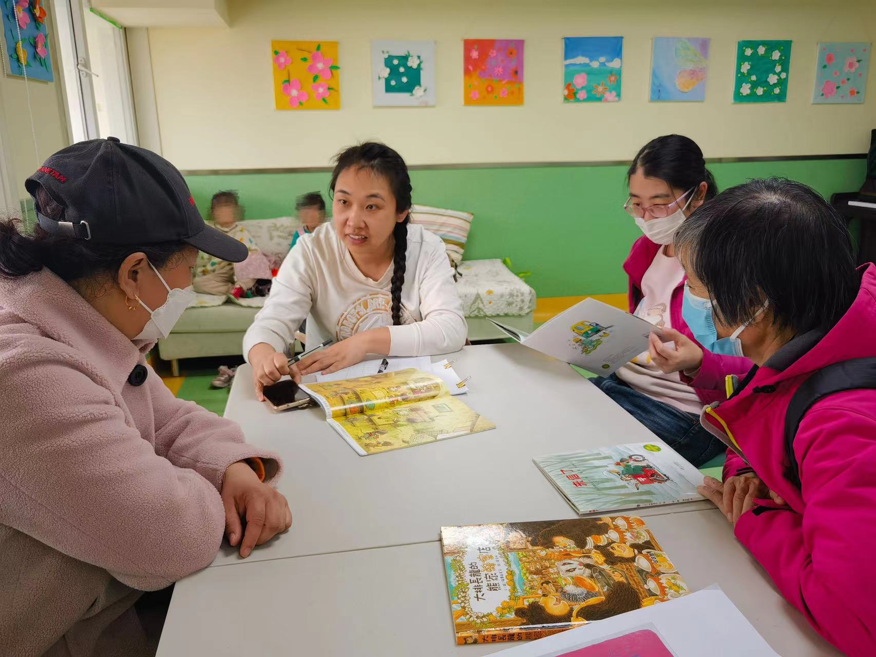 图为家长们参与“用心涂绘，走进春天”春日主题装饰画绘制活动