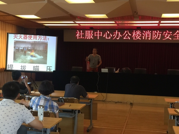 图为消防专家向大家演示灭火器的使用方法
