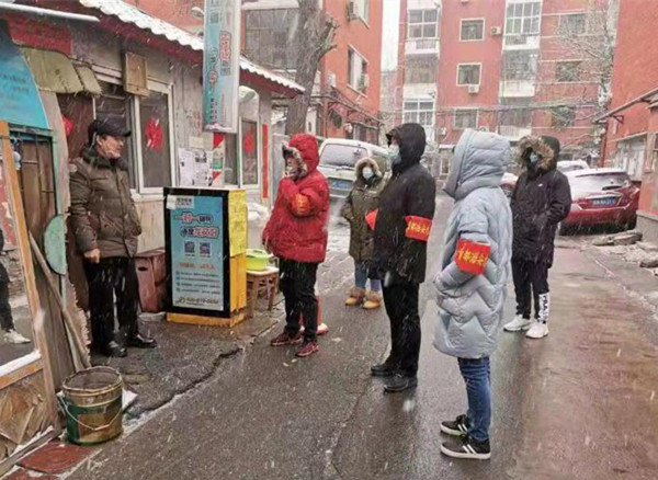 图为残联机关干部支援社区防控工作