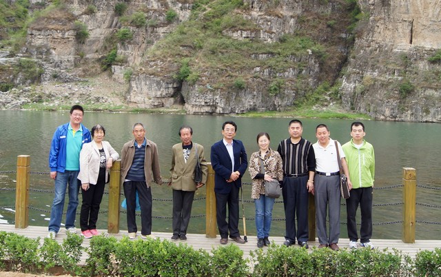图为部分盲人朋友和亲友在十渡山水前合影留念