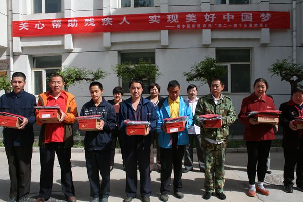 图为给温馨家园残疾人发放慰问品