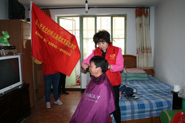 图为给重度残疾人上门理发