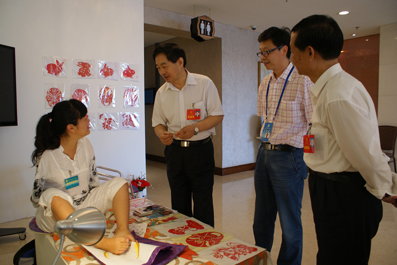 图片为：市委常委梁伟亲切与现场展示的残疾人亲切交谈