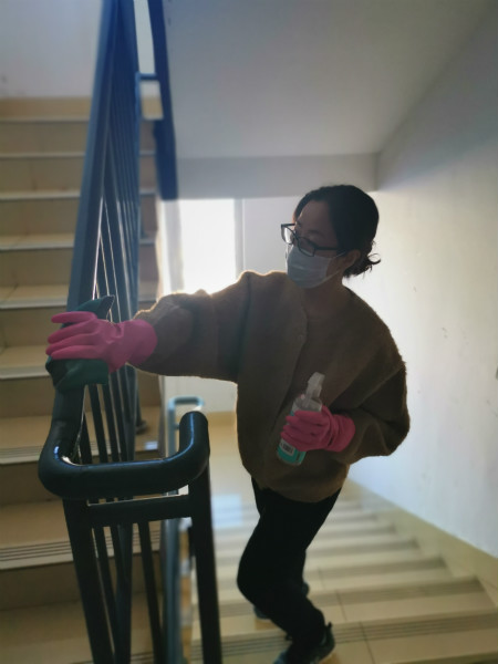 图为工作人员协助社区消毒