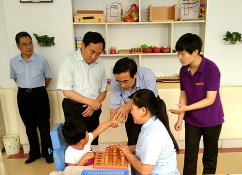 图为程凯一行看望学前部接受康复教育的孩子