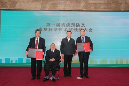 图为卢世璧院士和贾勇副理事长为第一届残疾预防及康复科学技术奖一等奖获奖代表颁奖