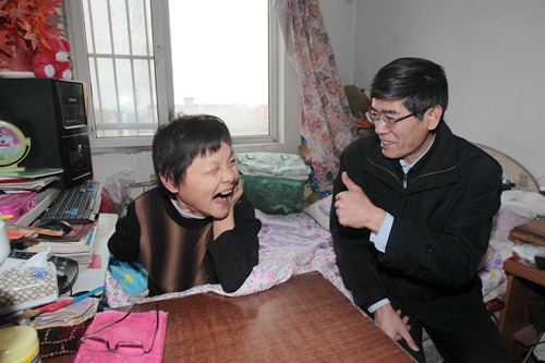 图为鲁勇书记和重度贫困残疾人张莉亲切交谈