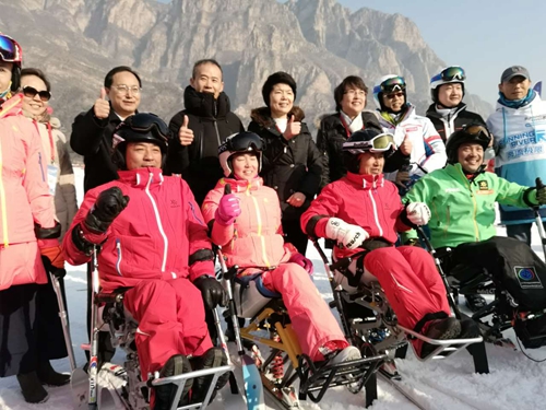 图为出席活动的有关领导与残疾人合影