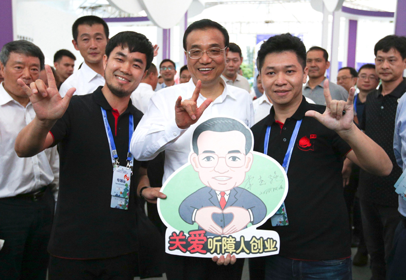 李克强用“爱”的手势为听障创业团队加油