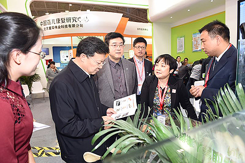 图为贾勇副理事长参观北京市残联展位