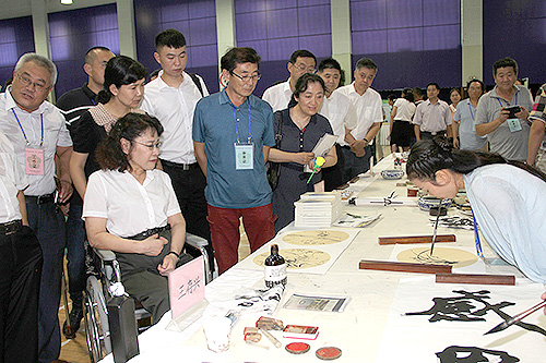 图为张海迪观摩残疾人书法绘画展示