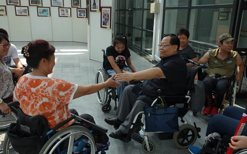 图为吕世明与中途之家生活重建训练营的学员交流