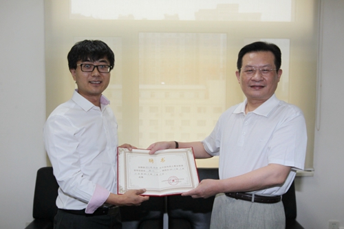 图为孙先德向胡百精颁发聘书