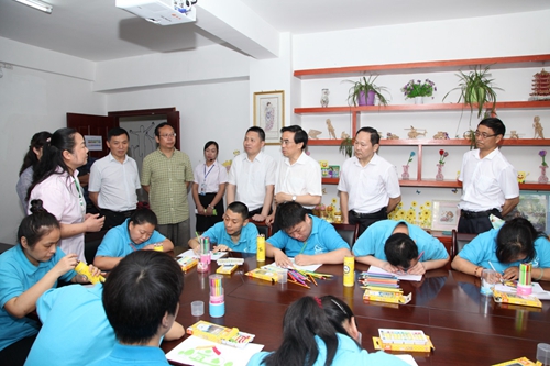 图为程凯一行到武汉市硚口区六角亭街“阳光驿站”观摩学习