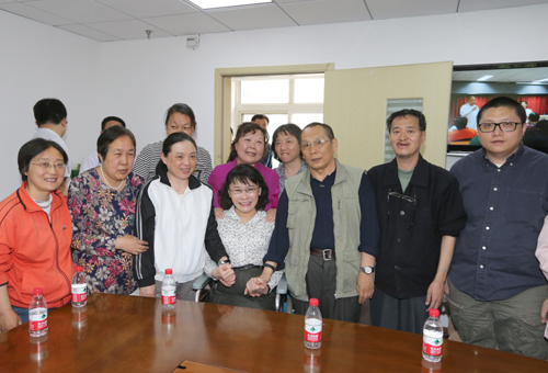 图为海迪主席和海淀区甘家口社区卫生服务中心的康复师及康复人员合影
