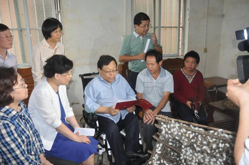 图为调研组一行在贫困残疾人家中了解精准识别、建档立卡、精准扶贫工作情况