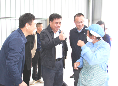 图为调研时与聋人职工交谈