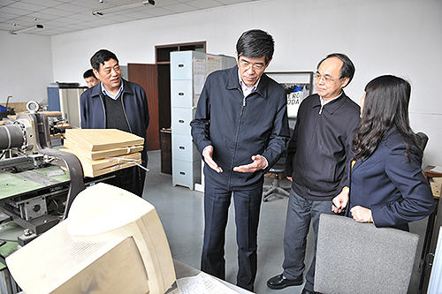 图为鲁勇在生产车间调研盲文出版工作