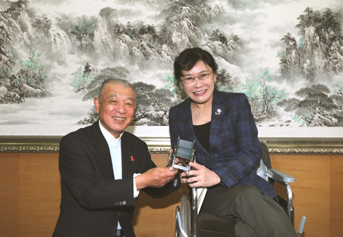 图为张海迪主席向笹川阳平赠送轮椅模型