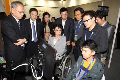 图为张海迪主席参观用眼睛取代键盘控制的电脑
