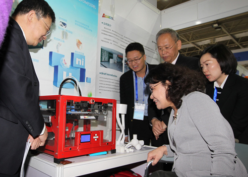 图为张海迪主席参观3D打印技术产品