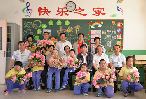 图为与残疾学生合影