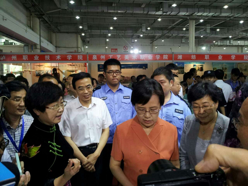 图为教育部副部长鲁昕和中国残联副理事长程凯参观山东特殊教育职业学院展位