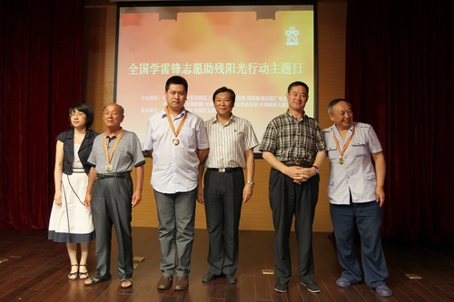 图为向模范助残志愿者陈欠水、任士荣、洪润浩颁发“中华助残志愿者阳光奖章”