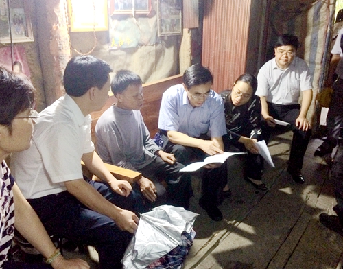 图为调研组在田东县作登瑶族乡贫困残疾人家里查看扶贫手册