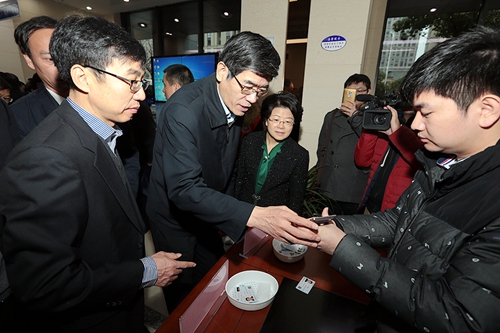 图为鲁勇书记观摩镇海区智能化残疾人证制发过程
