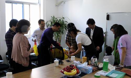 图为残联领导看望社会组织中的残疾儿童