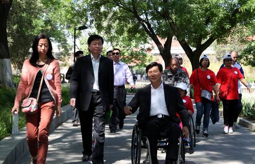 图为市区残联领导携手残疾人开展了“心手相牵，为爱行走活动”