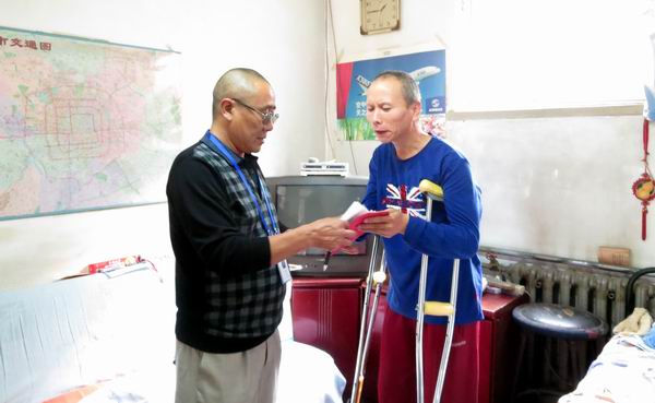 图为街乡镇残疾人工作者走访贫困残疾人