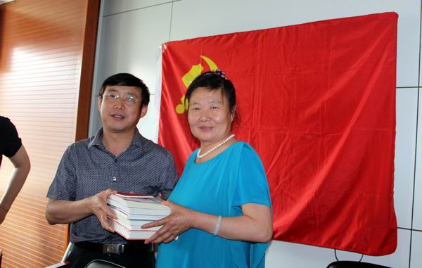 图为区残联领导为社会组织发放党建书刊