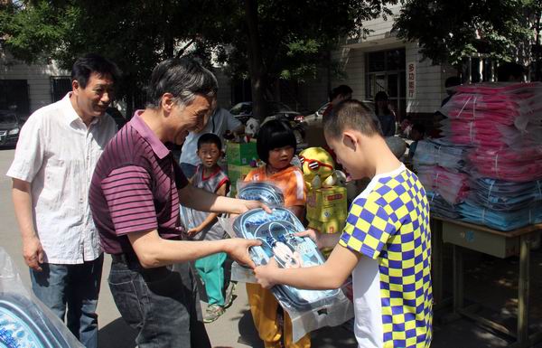 图为区残联领导为残疾儿童发学习用品