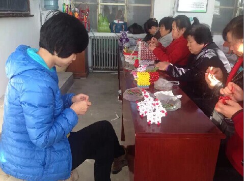 图为指导老师带领大家学习编织