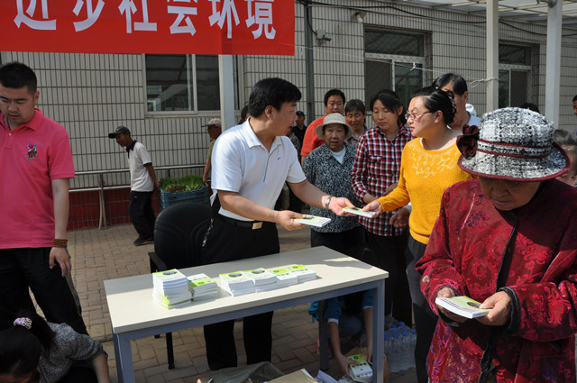 图为：顺义区残联副调研员吴建海现场为残疾人发放“口袋书”
