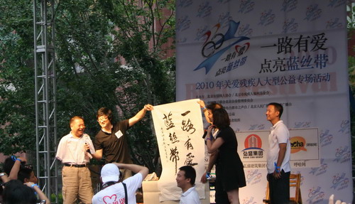 图为北京市肢残人协会主席刘京生出席活动并为活动题词“点亮蓝丝带”