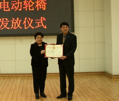 图为市残联副巡视员赵延红向捐赠方颁发荣誉证书和瓷盘